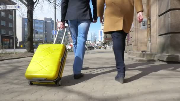 Young couple with rolling bag in the city - Footage, Video