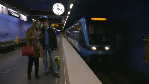 Young people with pad and suitcase in subway - Materiał filmowy, wideo