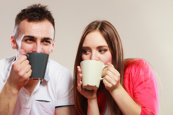 young couple holds mugs with tea or coffee - Zdjęcie, obraz