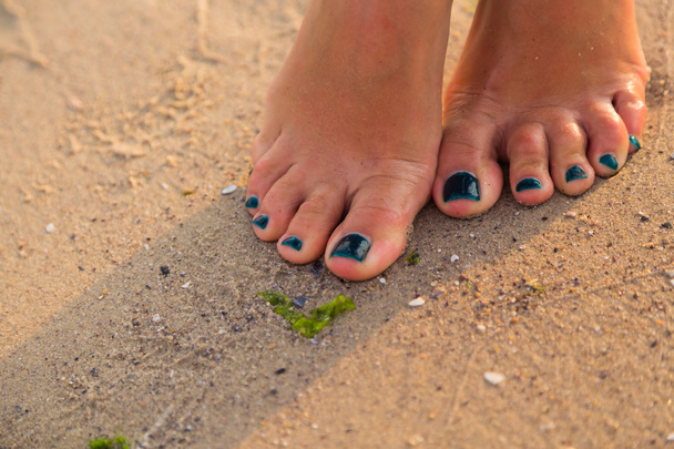 Baby en volwassen voeten op zee zand - Foto, afbeelding