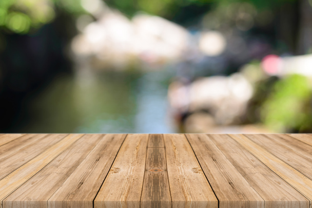 Holzbrett leerer Tisch vor verschwommenem Hintergrund. Perspektive graues Holz über unscharfe Bäume im Wald - kann für die Anzeige oder Montage Ihrer Produkte verwendet werden. Frühlingszeit. - Foto, Bild