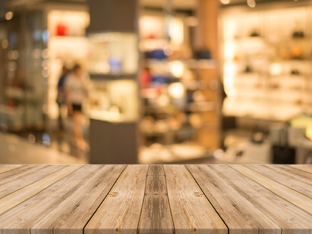 Holzbrett leerer Tisch vor verschwommenem Hintergrund. Perspektive braunes Holz über Unschärfe Store in Mall - kann für die Anzeige oder Montage Ihrer Produkte verwendet werden. - Foto, Bild