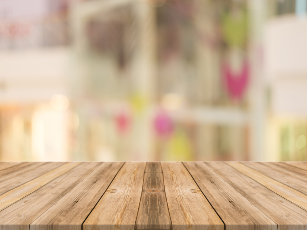 Tavola in legno tavolo vuoto di fronte a sfondo sfocato. Prospettiva legno marrone su negozio sfocatura nel centro commerciale - può essere utilizzato per visualizzare o montare i vostri prodotti
. - Foto, immagini