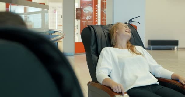 Mujer joven disfrutando del masaje en un sillón especial
 - Imágenes, Vídeo