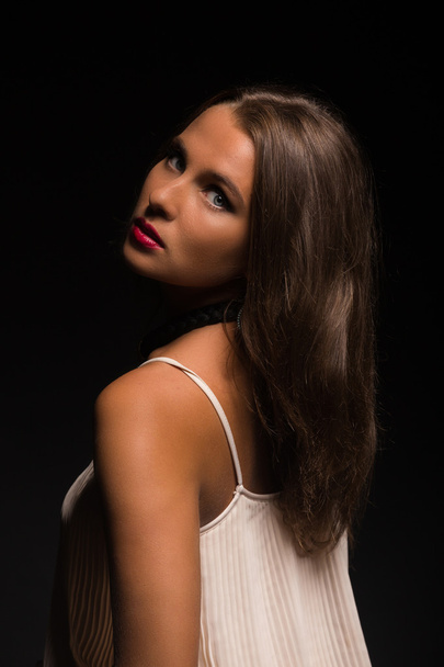 Beautiful brunette in a white dress on a dark background - Fotoğraf, Görsel