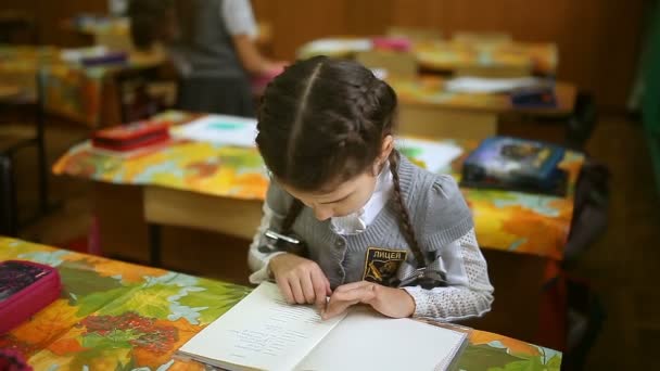 dospívající dívka číst knihu školačka sedí u stolu v učebně školy - Záběry, video