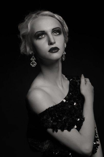 Mooie blonde in vintage jurk op een donkere achtergrond - Foto, afbeelding