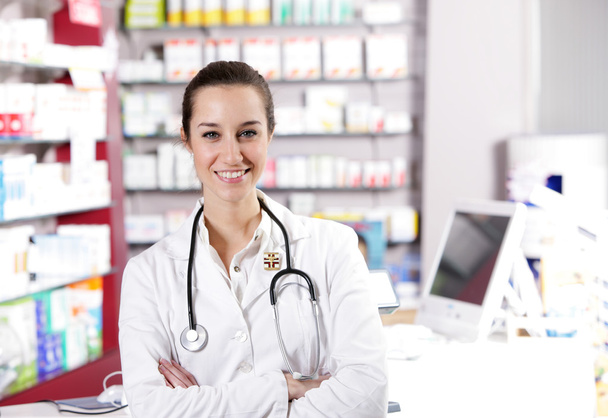 At pharmacy. A smiling young woman pharmacist with stethoscope - Zdjęcie, obraz