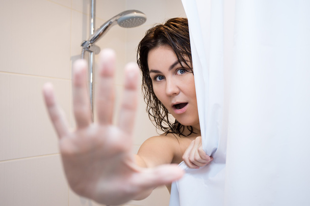 Junge Frau versteckt sich hinter Duschvorhang - Foto, Bild