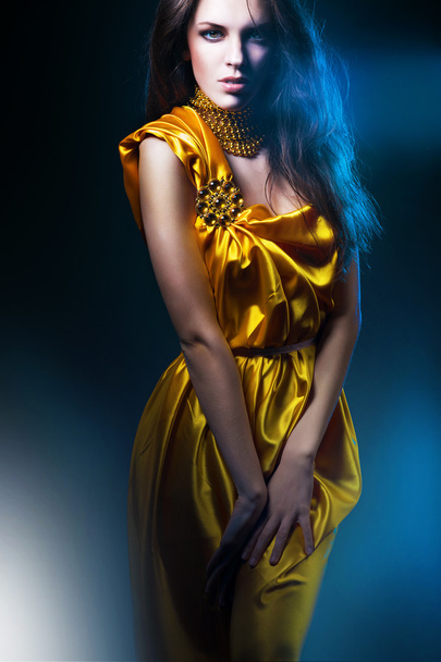 Beautiful woman in long dress with jewelry - Фото, зображення