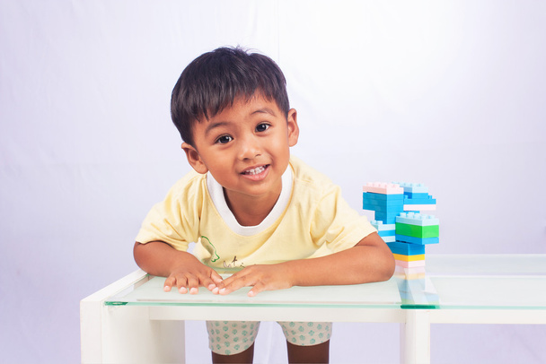 mały azjatycki chłopiec bawi się plastikowe kolorowe bloki w pokoju - Zdjęcie, obraz