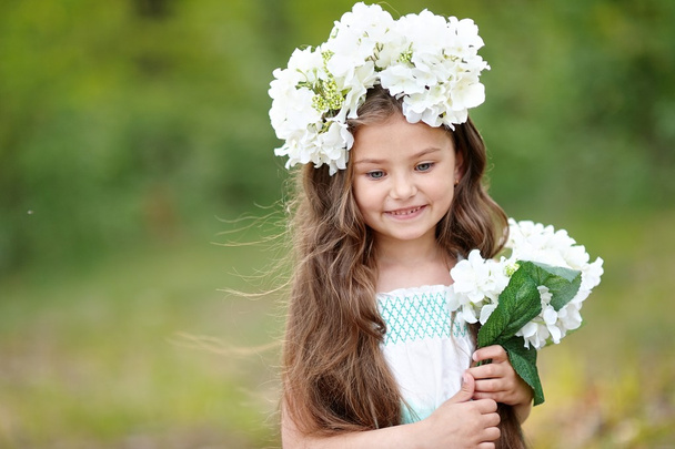 portrait of a beautiful little girl with flowers - Foto, afbeelding