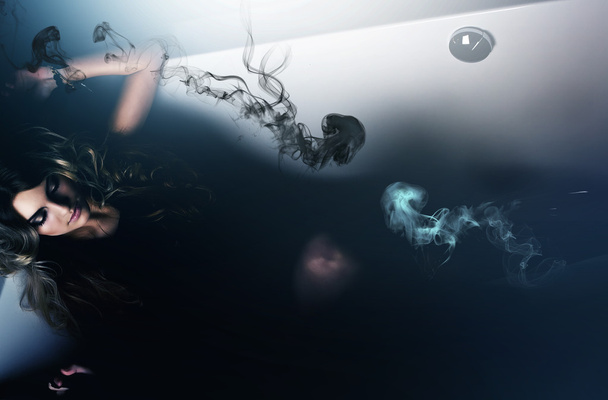 Hermosa mujer acostada en el baño con medusas
 - Foto, imagen
