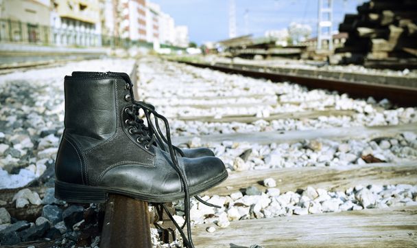 bottes pour hommes abandonnées sur les voies ferrées
 - Photo, image