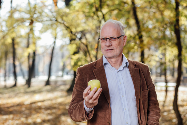 senior adult holding green apple - Valokuva, kuva