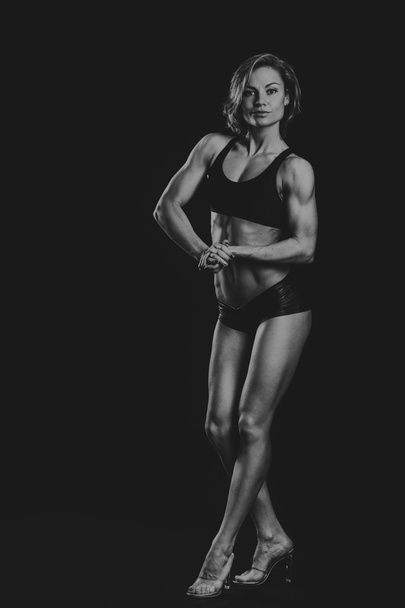 The beautiful sports girl on a dark background - Foto, Imagen