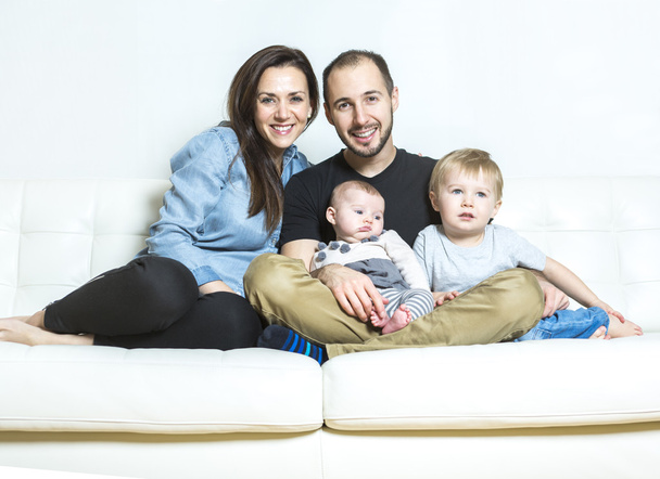 jonge gelukkig gezin met twee kinderen thuis - Foto, afbeelding