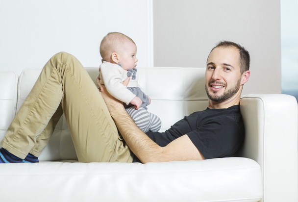 Father with baby on the sofa taking good time - Photo, image
