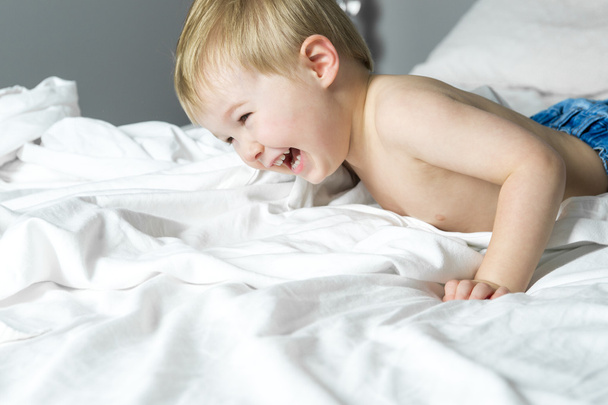 Healthy Lifestyle of young little children boy on bed - Fotó, kép