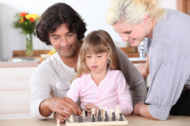 Young family playing chess - Foto, imagen