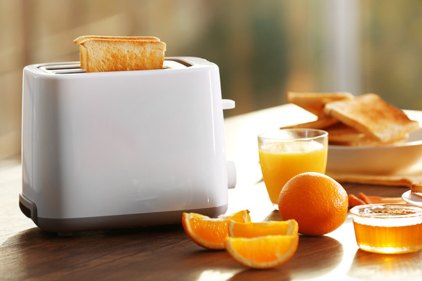 Served table for breakfast with toast and orange juice, on blurred background - Valokuva, kuva