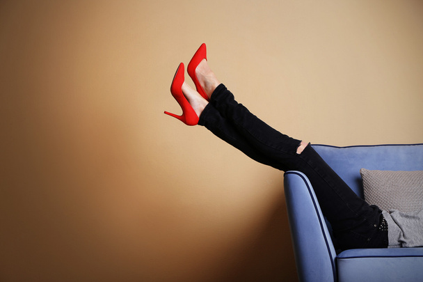 Woman legs on sofa with stylish shoes - Фото, изображение