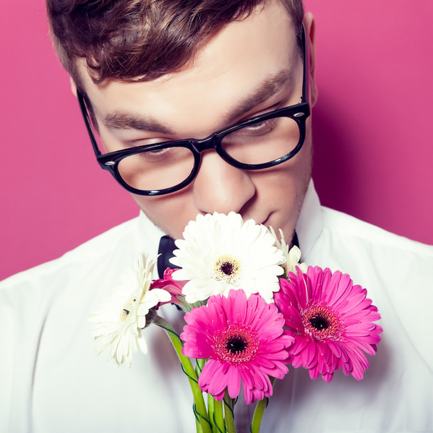 Young beautiful man with flowers - Φωτογραφία, εικόνα