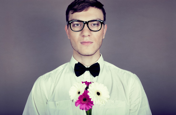 Young beautiful man with flowers - Fotó, kép