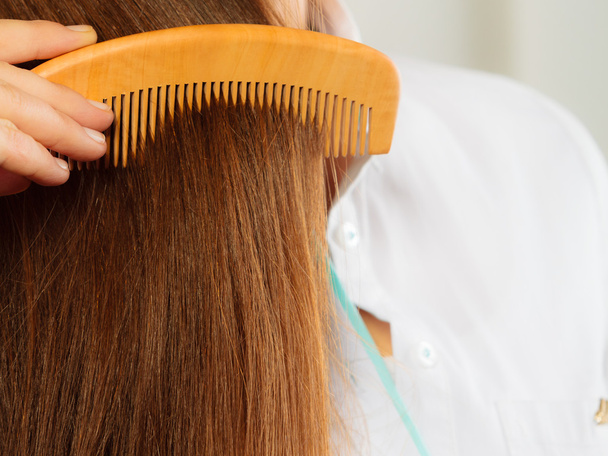 Closeup hair and hand with comb - Фото, изображение