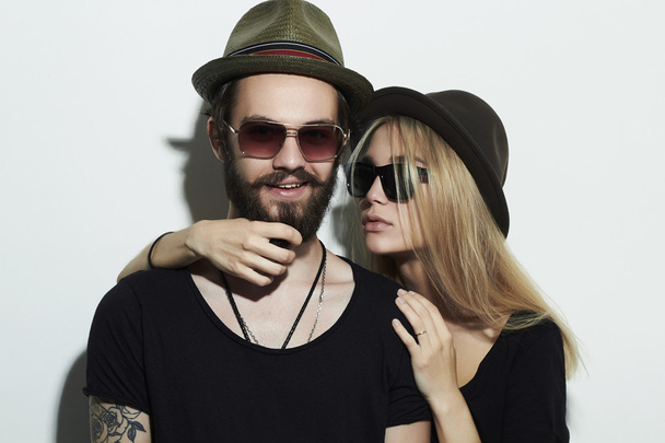 όμορφη ευτυχισμένο ζευγάρι με το καπέλο που φορούν μοντέρνα γυαλιά μαζί - Φωτογραφία, εικόνα