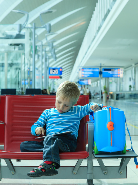 Havaalanında bekleyen dokunmatik yüzey ile küçük çocuk - Fotoğraf, Görsel