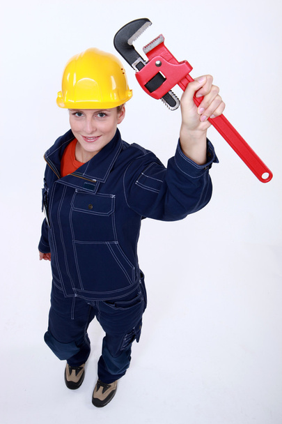 Female worker with an adjustable pipe wrench - Foto, Imagen