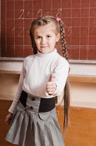 Маленькая девочка, стоящая возле доски в классе
 - Фото, изображение