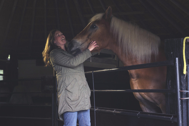 Onnellinen nainen halaamassa hevosta.
 - Valokuva, kuva