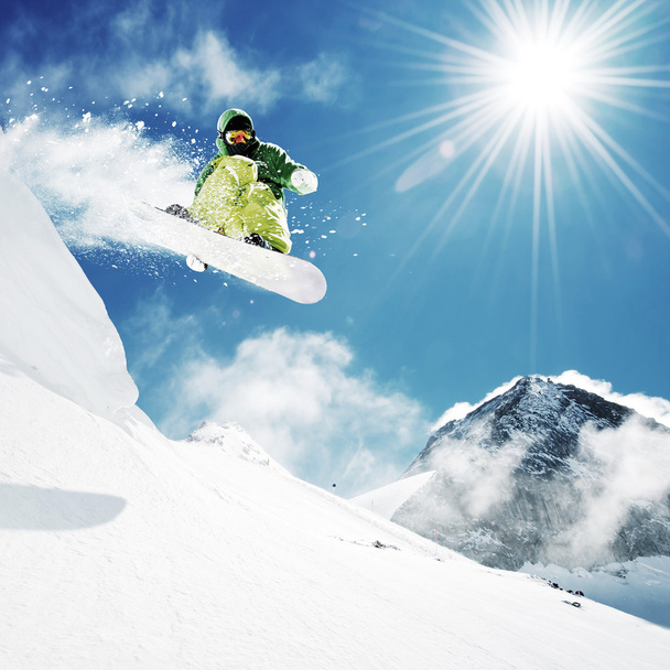snowboarder op sprong inhigh bergen - Foto, afbeelding