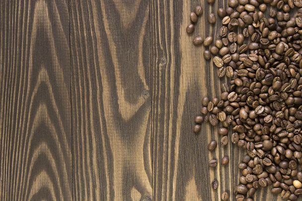 Fondo derramado granos de café sobre una mesa de madera. Cultivo. Vista superior
 - Foto, Imagen