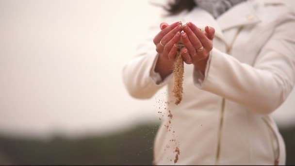 kobiety dziewczyny duże ręce rzuca piasek czasu symbol jesień zimno białe tło - Materiał filmowy, wideo