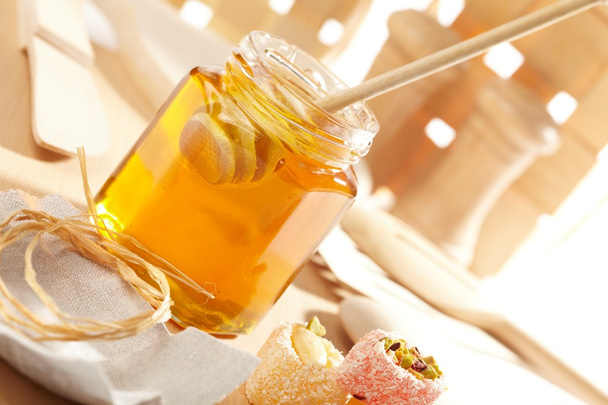 Honey with wood stick - Foto, afbeelding