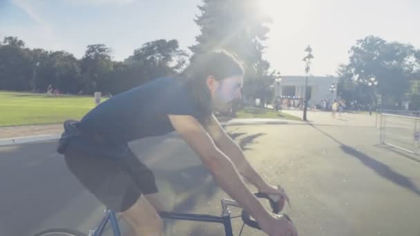 joven guapo hombre monta una bicicleta a través del parque cámara lenta
 - Metraje, vídeo