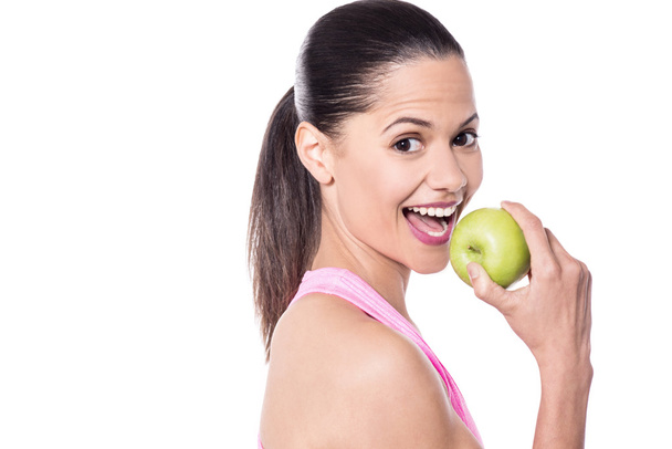 Cheerful woman eating fresh green apple - Photo, Image