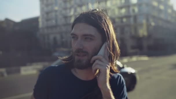 joven motociclista habla por teléfono en la ciudad en cámara lenta
 - Metraje, vídeo