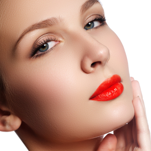 Крупный план портрета чистоты лица красивой женщины с ярко-красным макияжем губ. Симпатичная модель с чистой блестящей кожей
 - Фото, изображение