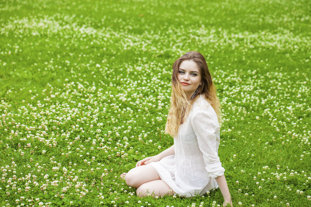 Young blonde woman on green meadow  - Valokuva, kuva