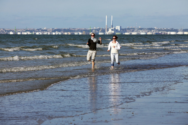 Twee vrouwen loopt langs het strand - Foto, afbeelding