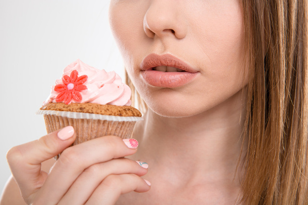 Pretty sensual woman trying to eat a cupcake - Photo, Image