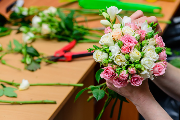 closeup florist making a bouquet of flowers. Shallow depth of fi - Photo, image