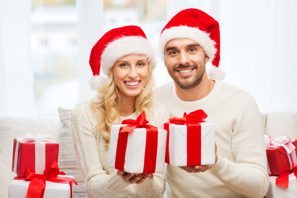 щаслива пара вдома з різдвяними подарунковими коробками
 - Фото, зображення