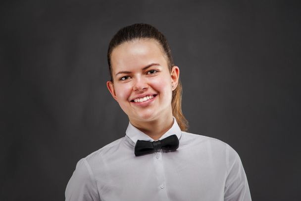 Young woman in waiter uniform over dark background. - Photo, Image