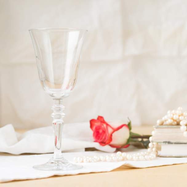 Beautiful empty glass with vintage books and pearls - Fotó, kép