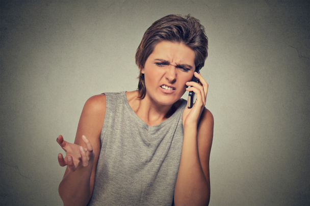 Upset skeptical, unhappy angry woman talking on phone - Фото, изображение